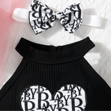 Black dress with white lettering and matching headband on a textured background