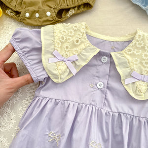 Baby romper with embroidered details and a decorative collar.