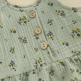 Green baby clothes with floral pattern and wooden buttons