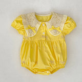 Yellow baby romper with lace details.