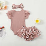 Baby outfit set with pink ruffled romper, matching headband, and floral bloomers