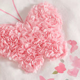Baby girl toddler suit with Heart-shaped pink flower arrangement on a light background with pink butterflies.