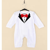 White baby romper with black bow tie and red bow on a beige background